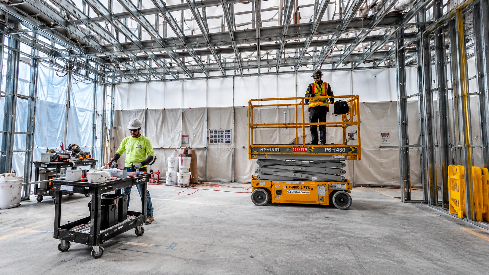 Commercial interior metal framing installation with overhead framing and access equipment